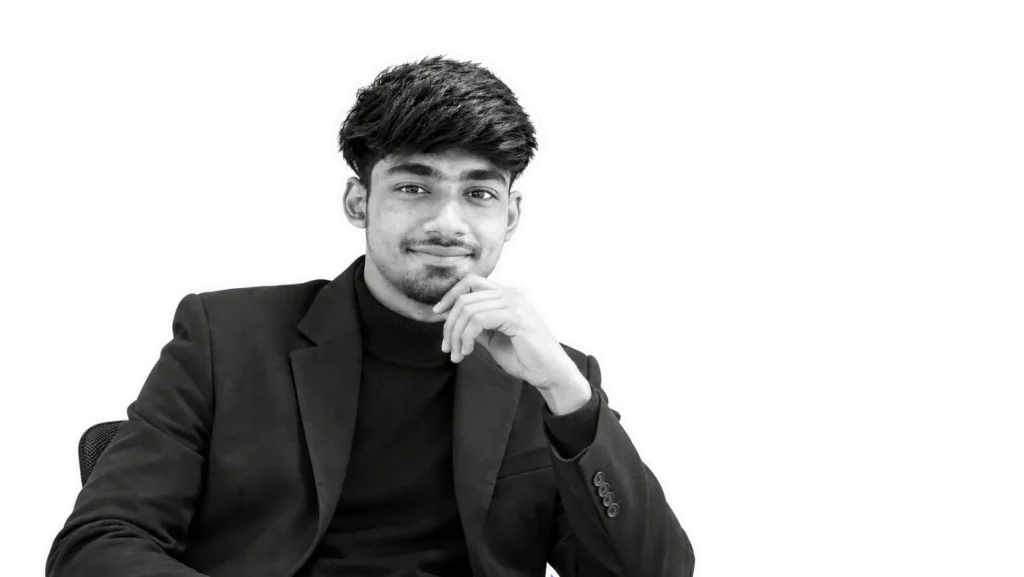 Rimon Babu sitting in suit with hand on chin on dark background