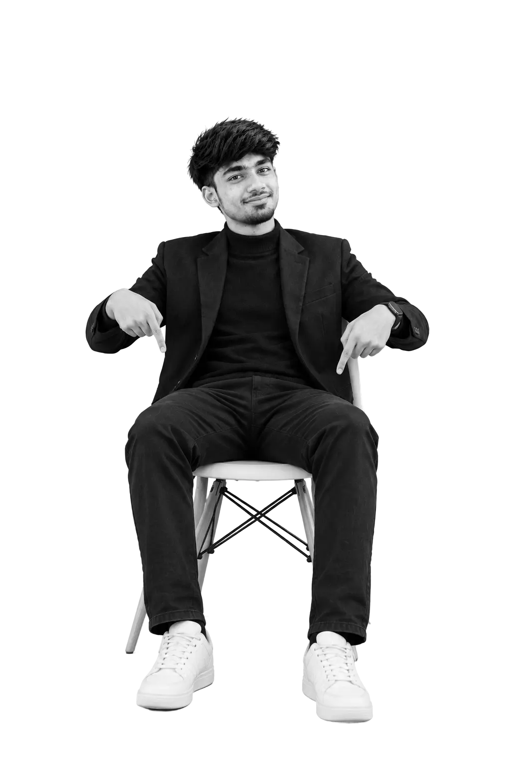 Rimon Babu sitting on chair pointing down wearing black suit and white sneakers